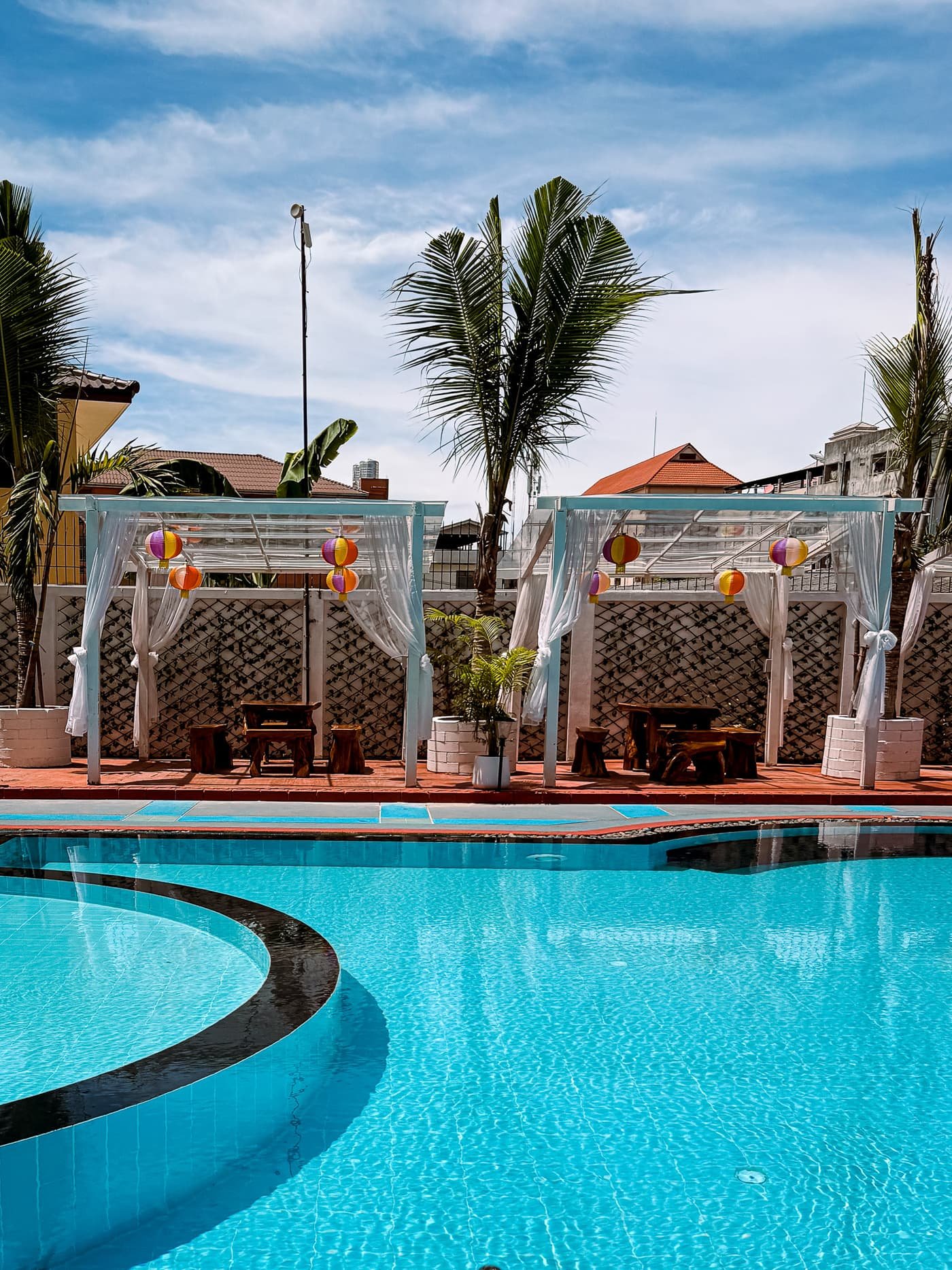 Resort swimming pool with private sun cabanas and daybeds